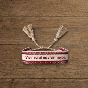 pulsera de tela con la frase "vivir rural es vivir mejor" blanca y carmín