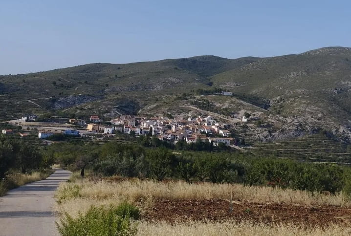 pueblo de Fageca desde un punto de vista lejano en una carretera. El pueblo esta situado justo en el final de la montaña.