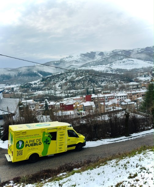 Clínica móvil aparcada en un pueblo rural nevado en la montaña.