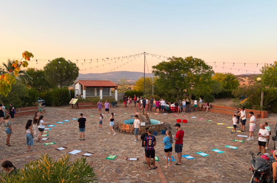 Jóvenes participando en una actividad al aire libre organizada por la Asociación Juvenil de Tamurejo, en la plaza del pueblo al atardecer